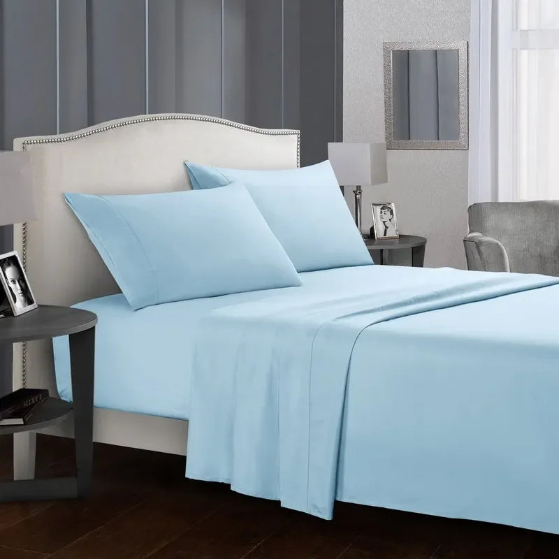 A light blue bedding set featuring a fitted sheet, flat sheet, and pillowcases on a bed in a modern bedroom.