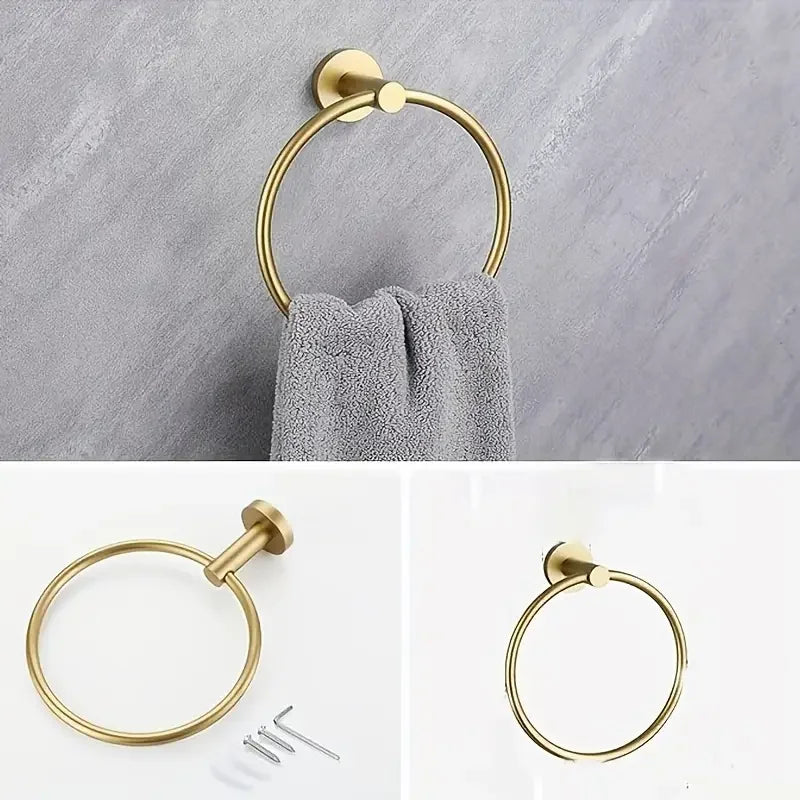 A set of four gold-toned stainless steel bathroom accessories including a toilet paper holder, towel ring, and hooks.