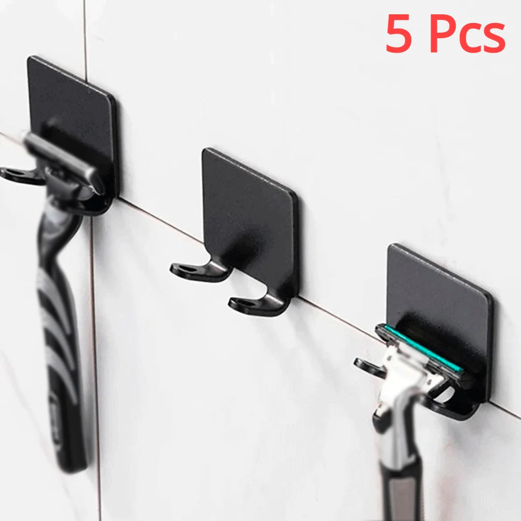 Five black aluminum wall-mounted adhesive razor holders displayed against a white tiled surface.