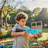 A young boy is holding and aiming a blue manual foam dart blaster toy for kids outdoors.