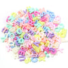 Haufen gemischter Buchstaben-Spacer-Perlen in Pastellfarben wie rosa, blau, gelb und weiß.