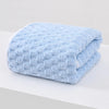 A folded light blue plush bath towel with a textured, quilted pattern.
