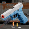 A white and blue toy pistol is shown with a detachable shell ejecting mechanism, resting on a wooden surface.