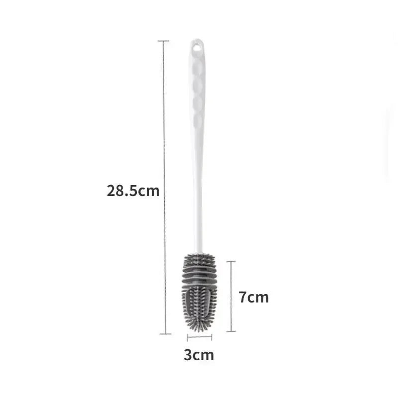 A silicone bottle brush with a long handle and a bristled cleaning head is shown.