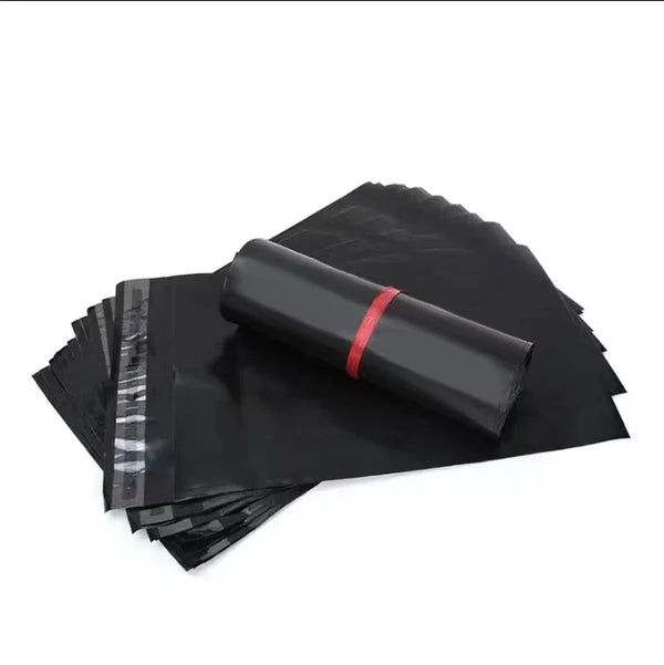 Stack of black self-adhesive peel-and-seal plastic mailing bags with a rolled bag on top