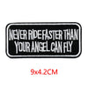 Black embroidered iron-on letter patch with white text that reads Never ride faster than your angel can fly