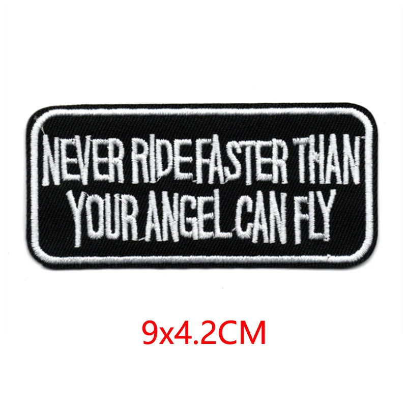 Black embroidered iron-on letter patch with white text that reads Never ride faster than your angel can fly
