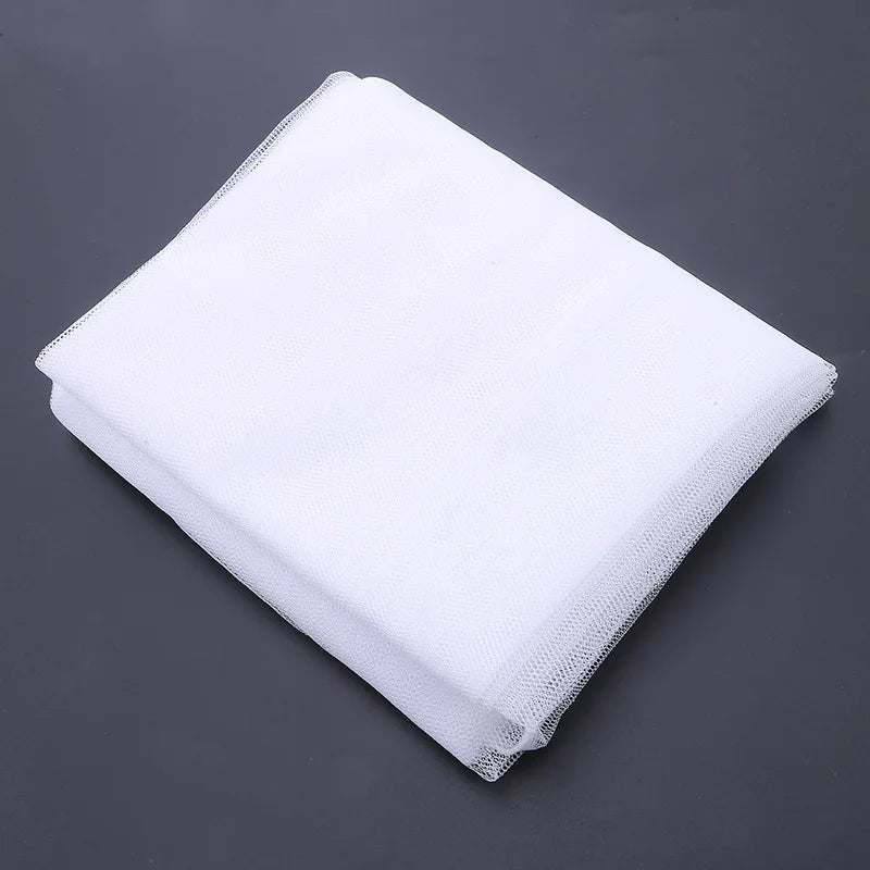 White breathable mosquito net for baby cribs displayed flat on a dark gray surface.