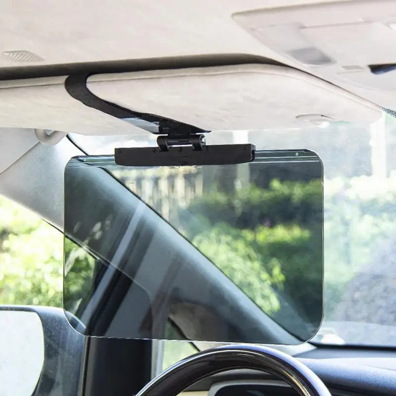 A clear anti-glare car sun visor extender is mounted on a vehicle window.