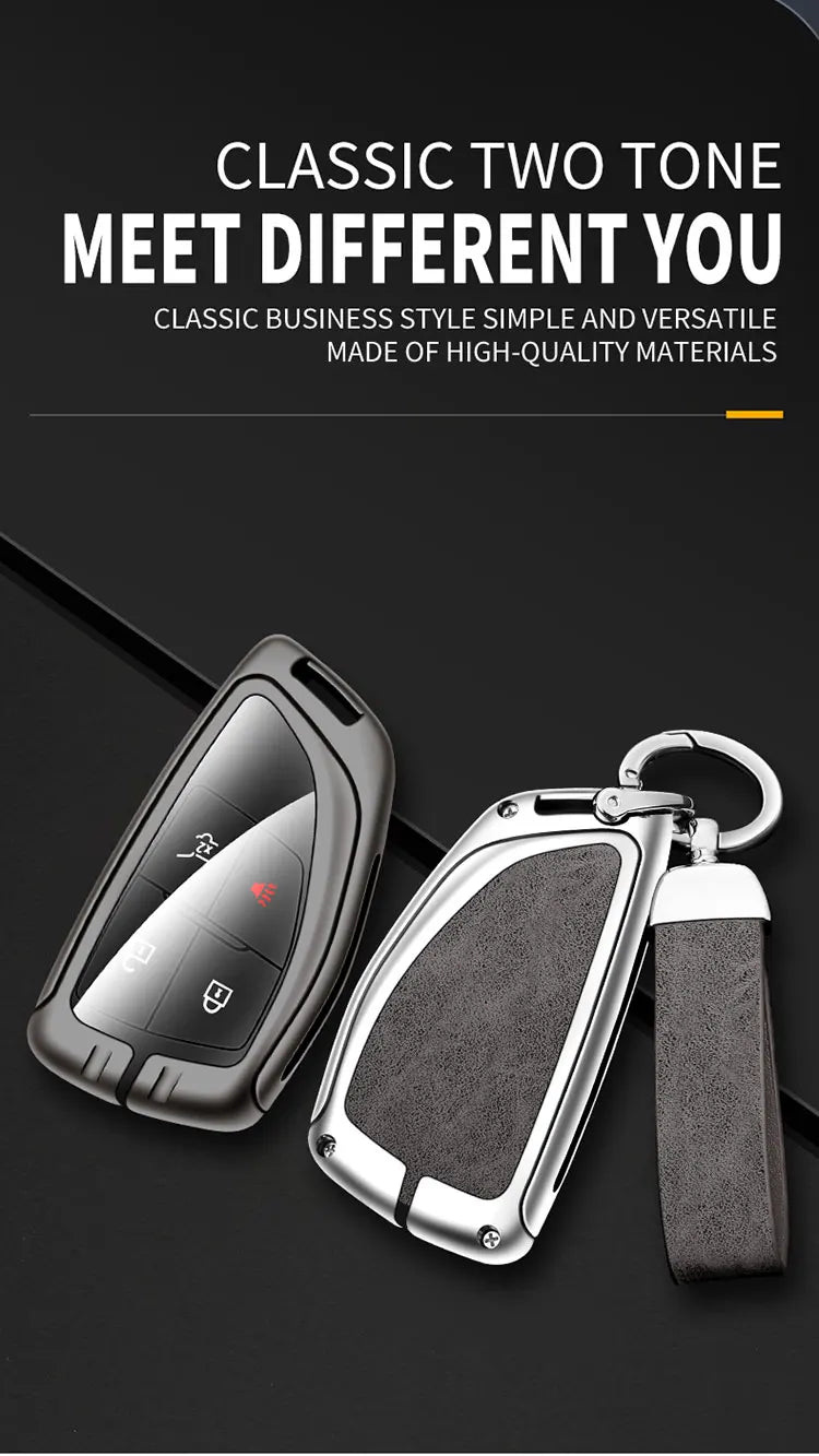 A black key case with a silver metal key and a dark gray leather strap is shown on a black background.