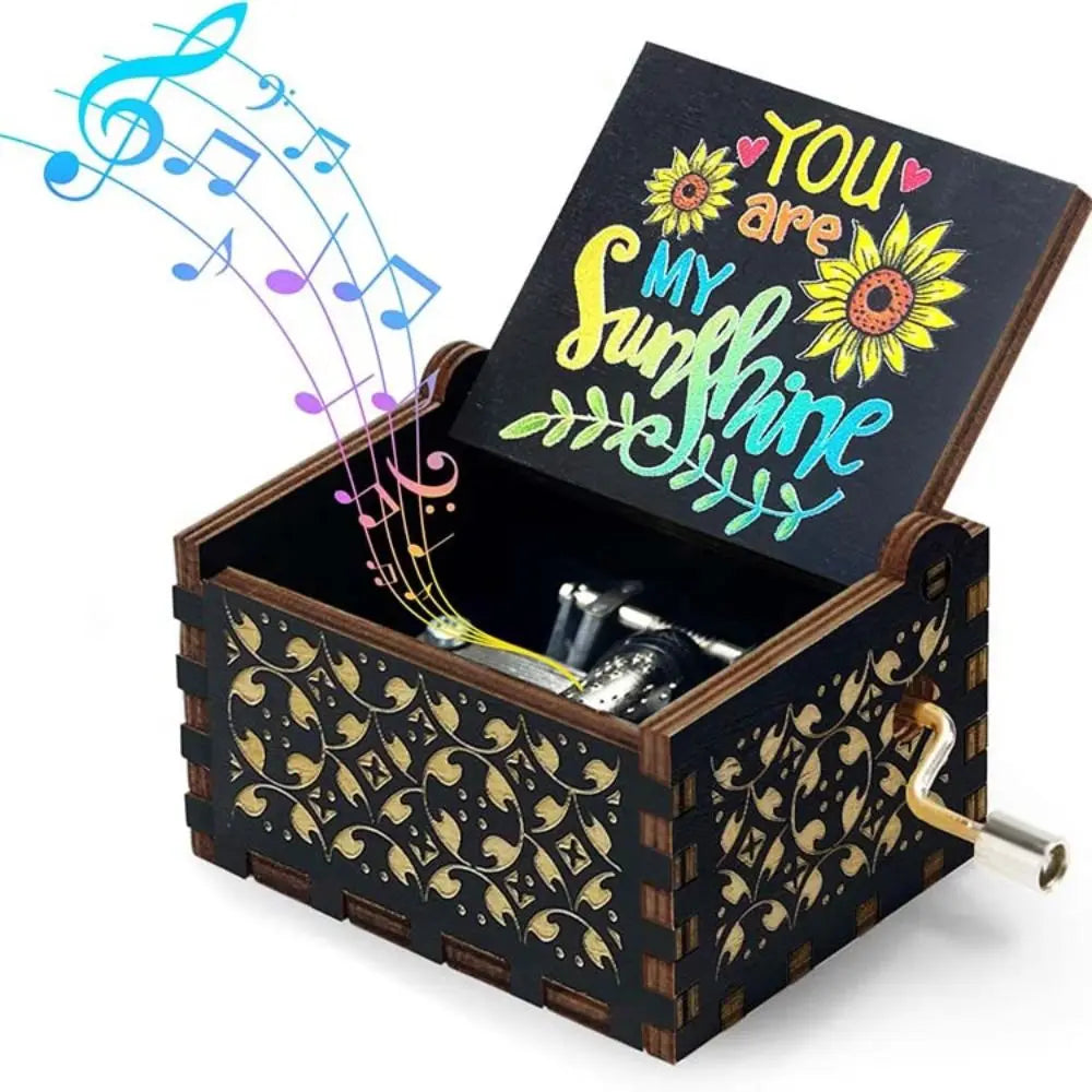 A vintage hand-cranked wooden music box with a lid open, featuring a sunflower design and musical notes.