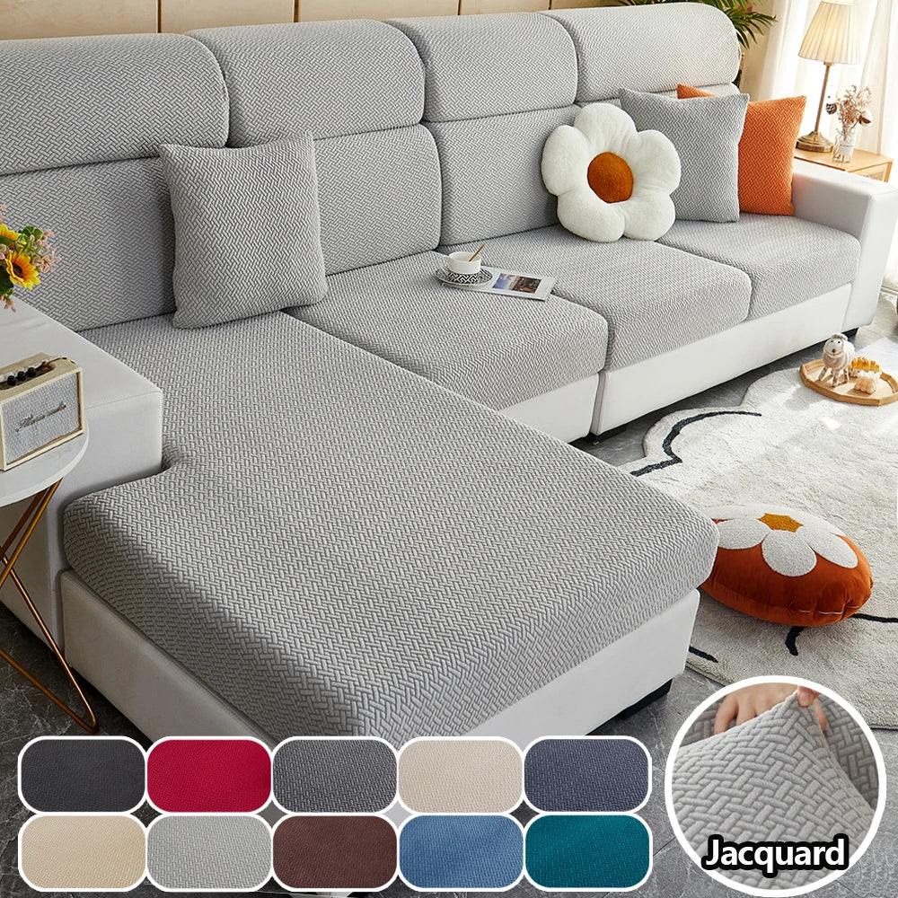 A light gray elegant sofa slipcover featuring a textured fabric and orange accent pillows.