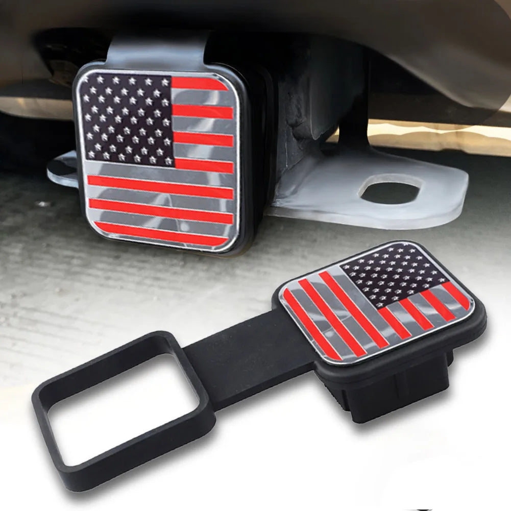 A black trailer hitch receiver cover featuring an American flag emblem with red and white stripes.