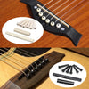 A set of guitar accessories including strings, a capo, and picks displayed on a wooden surface.