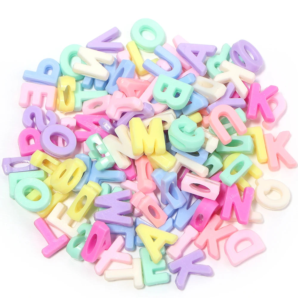 Haufen gemischter Buchstaben-Spacer-Perlen in Pastellfarben wie rosa, gelb, blau und grün.