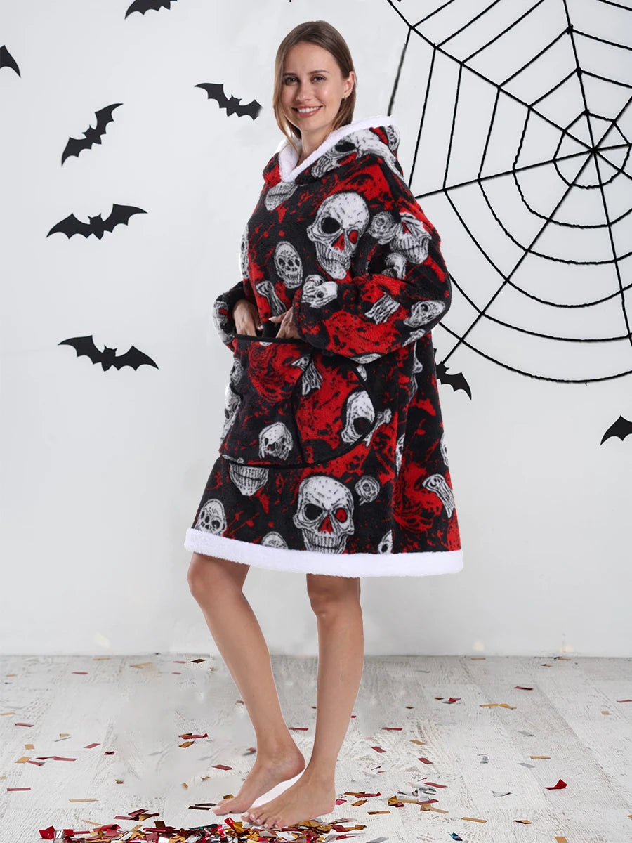 Eine Frau modelliert einen kuscheligen, oversized Fleece-Hoodie mit Totenkopf-Aufdruck vor einer weißen Wand mit schwarzen Fl