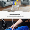 A hand is using a blue microfiber duster with a removable handle design to clean a surface.