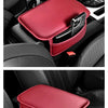 A red PU leather car armrest cover with a storage bag is shown inside a black car interior.