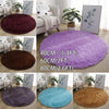 A collection of ultra-soft shaggy round rugs in various colors including purple, maroon, blue, and brown.