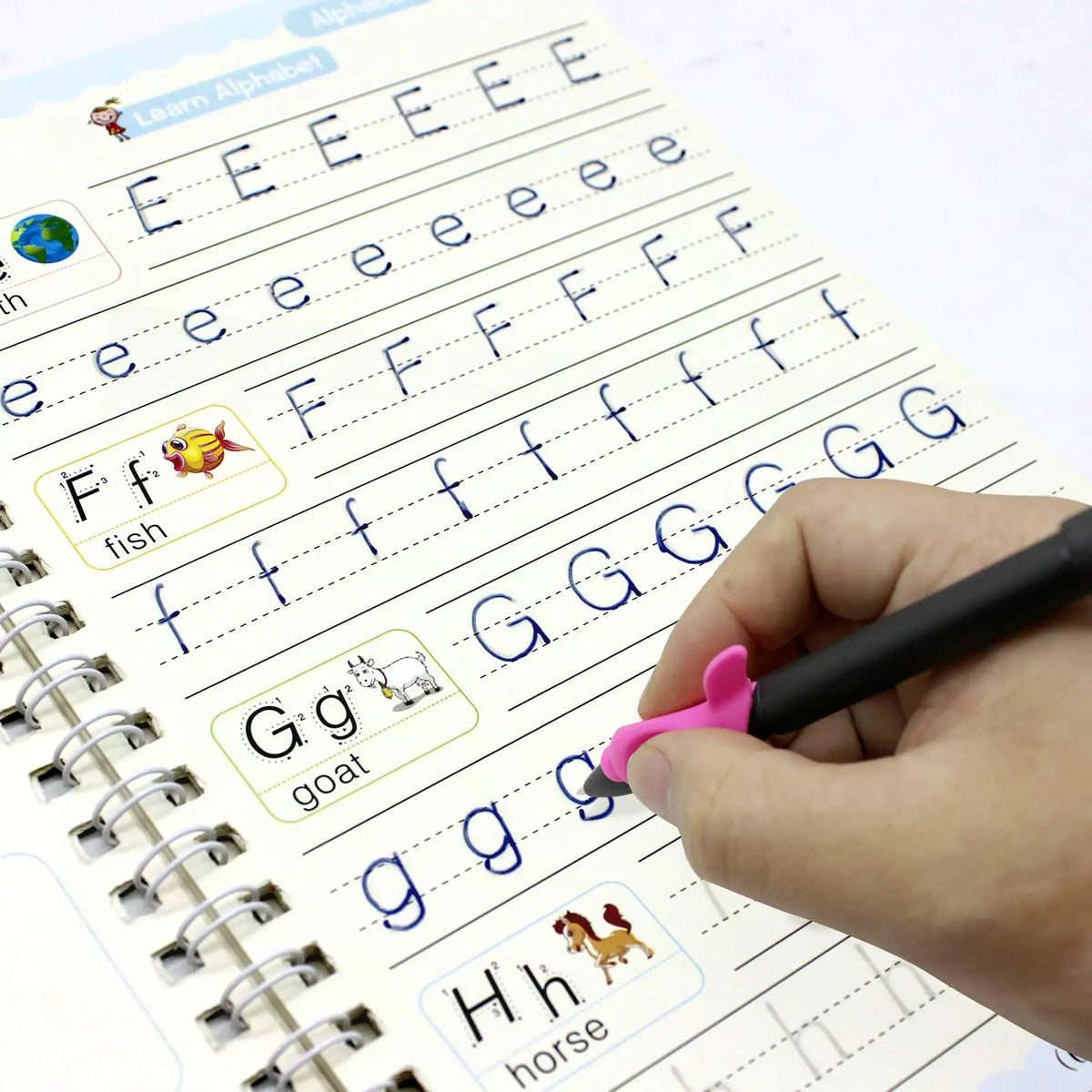A hand writes letters and sounds in a handwriting practice book with various phonetic examples like ff, gg, and hh.