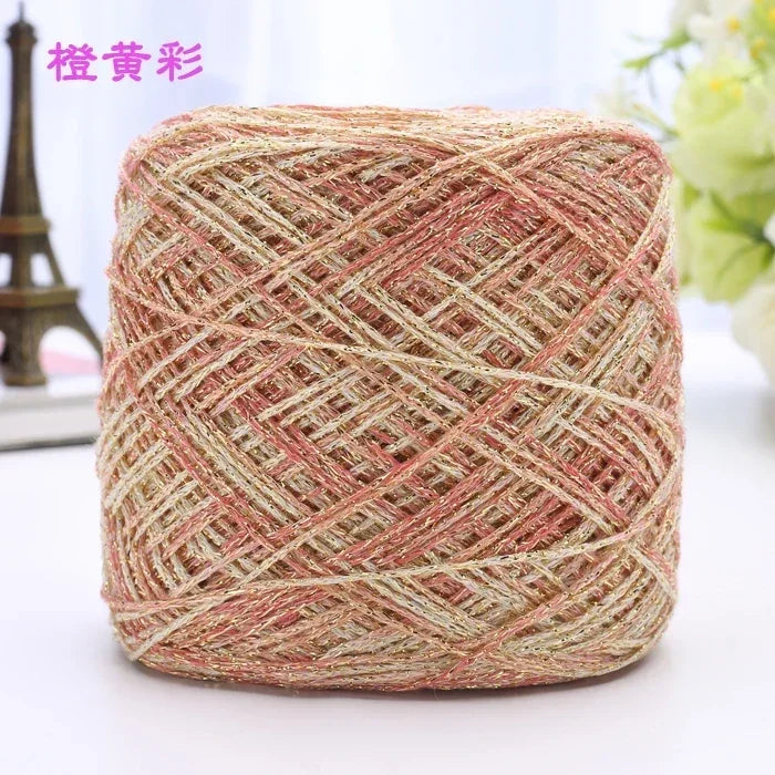 A ball of metallic silk crochet yarn with a pink and silver shimmer texture for knitting and macrame.