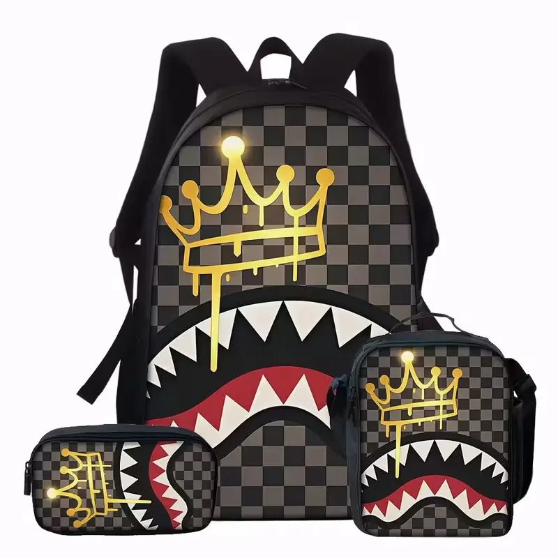 A black backpack and matching pouch featuring a gold crown and shark graphic print on a checkered background.