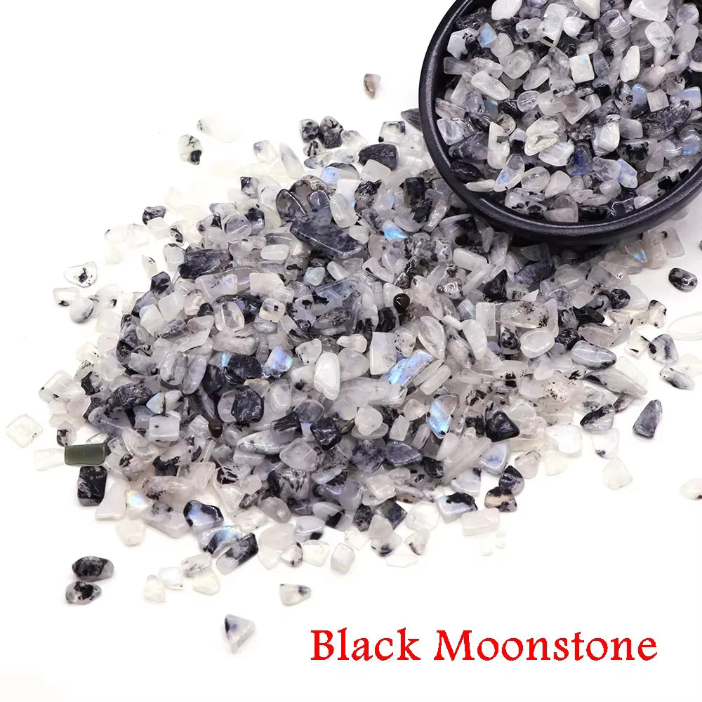 A pile of black moonstone crystal chips and tumbled stones for healing and decoration.
