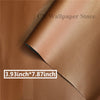 Close-up of a brown leather material showing a stitched edge and a size measurement label.
