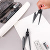 A hand holds a black geometry drafting set including a compass and ruler on a white sheet of paper.