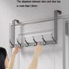 A close-up of a silver over-the-door organizer rack with eight hooks being installed on a white door frame.