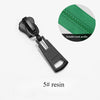 A black plastic zipper slider repair kit with a green fabric piece showing a suitable tooth profile.