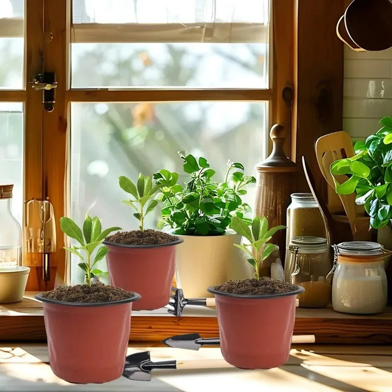 A collection of pink and beige reusable plastic seedling pots for indoor and outdoor gardening displayed on a wooden surface.
