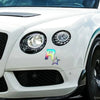 Close-up of a white car's front grille and headlights featuring an R-Star reflective decal.
