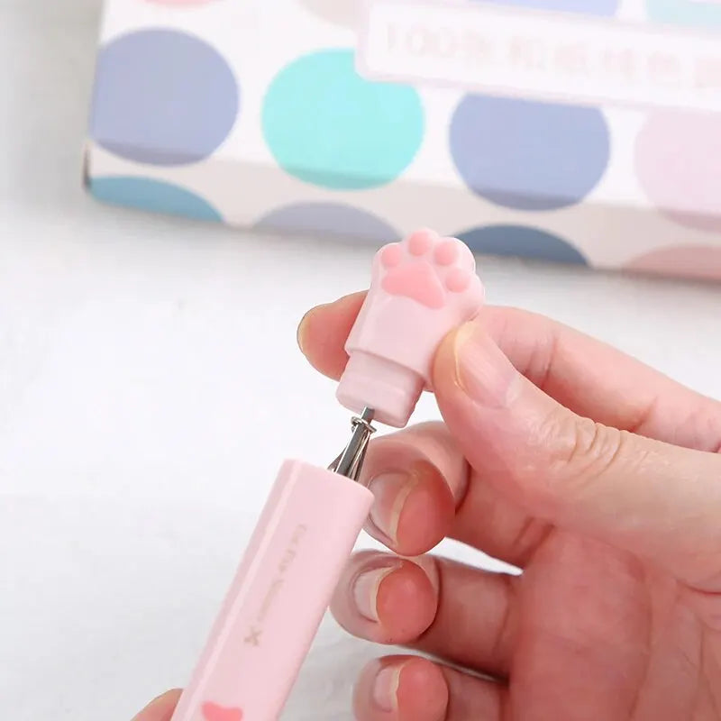 A hand holds a pink stainless steel cat paw portable scissor tool.