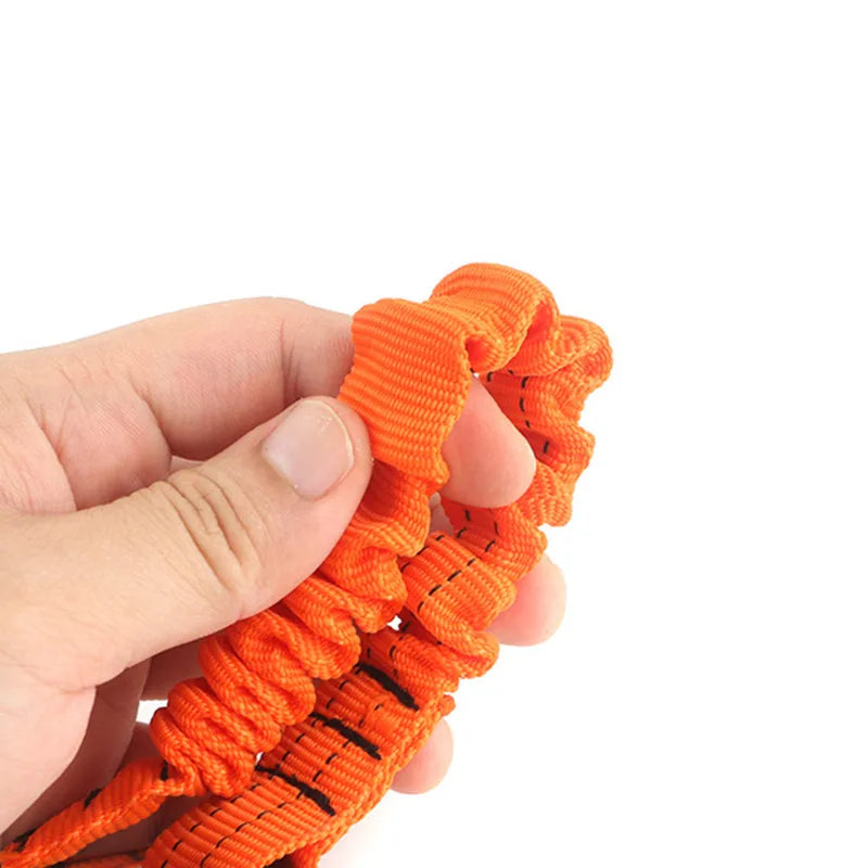 Une main tient une corde élastique orange réglable avec des accents noirs.
