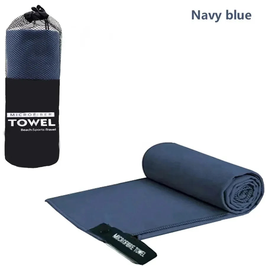 Navy blue microfiber towel rolled up and a flat towel displayed on a white background.