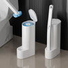 A white disposable toilet brush set with a replaceable blue head and a tall white holder is shown on a floor.