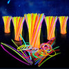 A collection of bright, bendable glow sticks in various colors are displayed against a dark background.