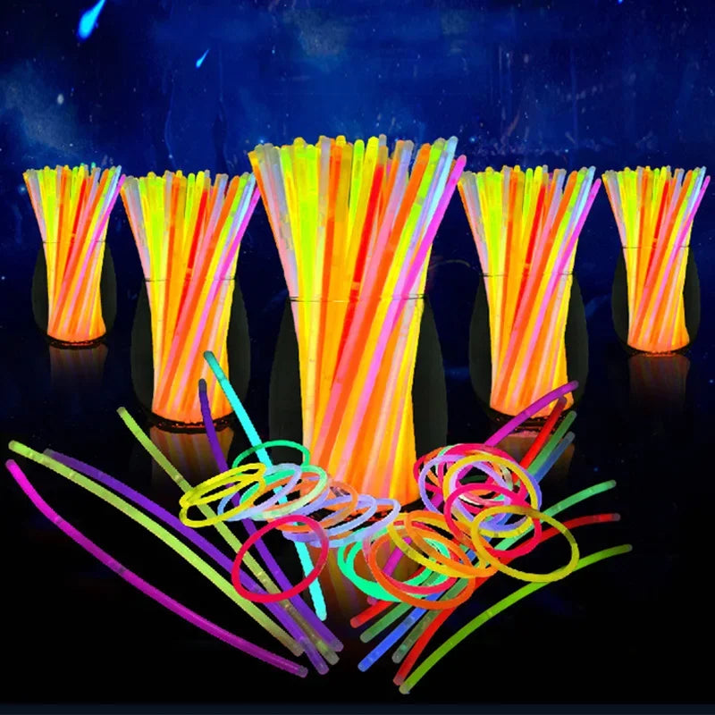 A collection of bright, bendable glow sticks in various colors are displayed against a dark background.