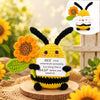 Handmade crochet bee plush doll with black and yellow stripes and orange flower accents