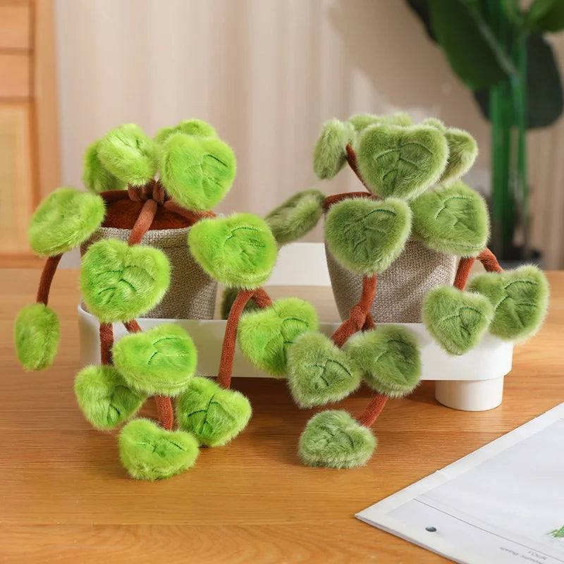 A set of lifelike plush green pothos plants in terracotta pots with brown stems and leaves on a wooden surface.