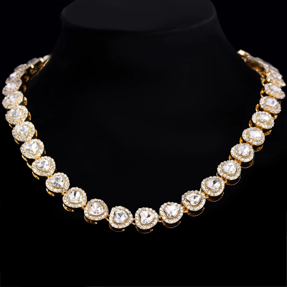 Collier de tennis en strass doré sur socle velours noir.