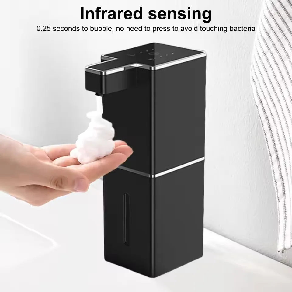 A hand is dispensing soap into a touchless infrared sensor dispenser with a white bubble.