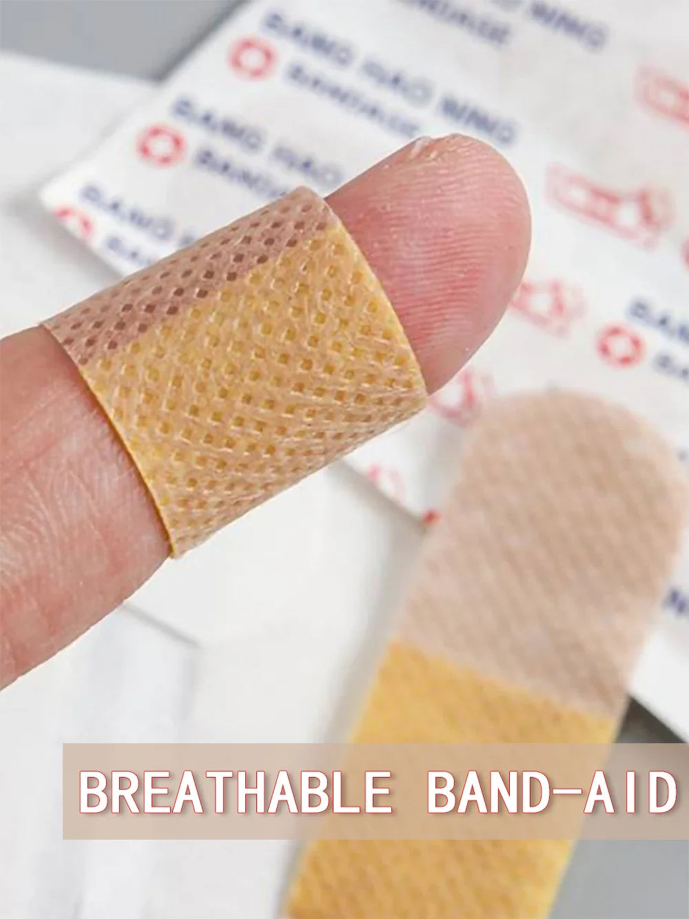 A hand holds a square, yellowish adhesive bandage with a honeycomb texture against a white background.