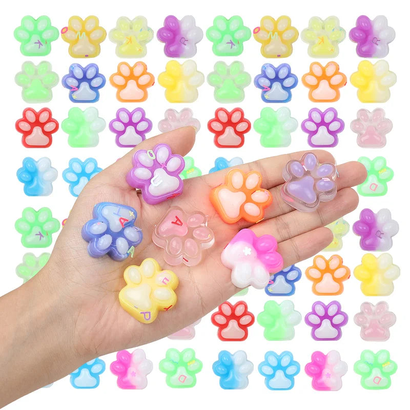 A hand holds a variety of colorful squishy cat paw fidget toys for stress relief and sensory play.