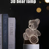 A white wireframe 3D bear lamp displayed on a stand against a dark background.