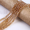 A string of faceted amber crystal glass spacer beads is wrapped around a cylindrical object.
