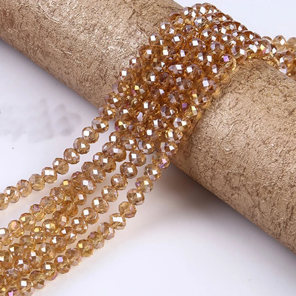 A string of faceted amber crystal glass spacer beads is wrapped around a cylindrical object.