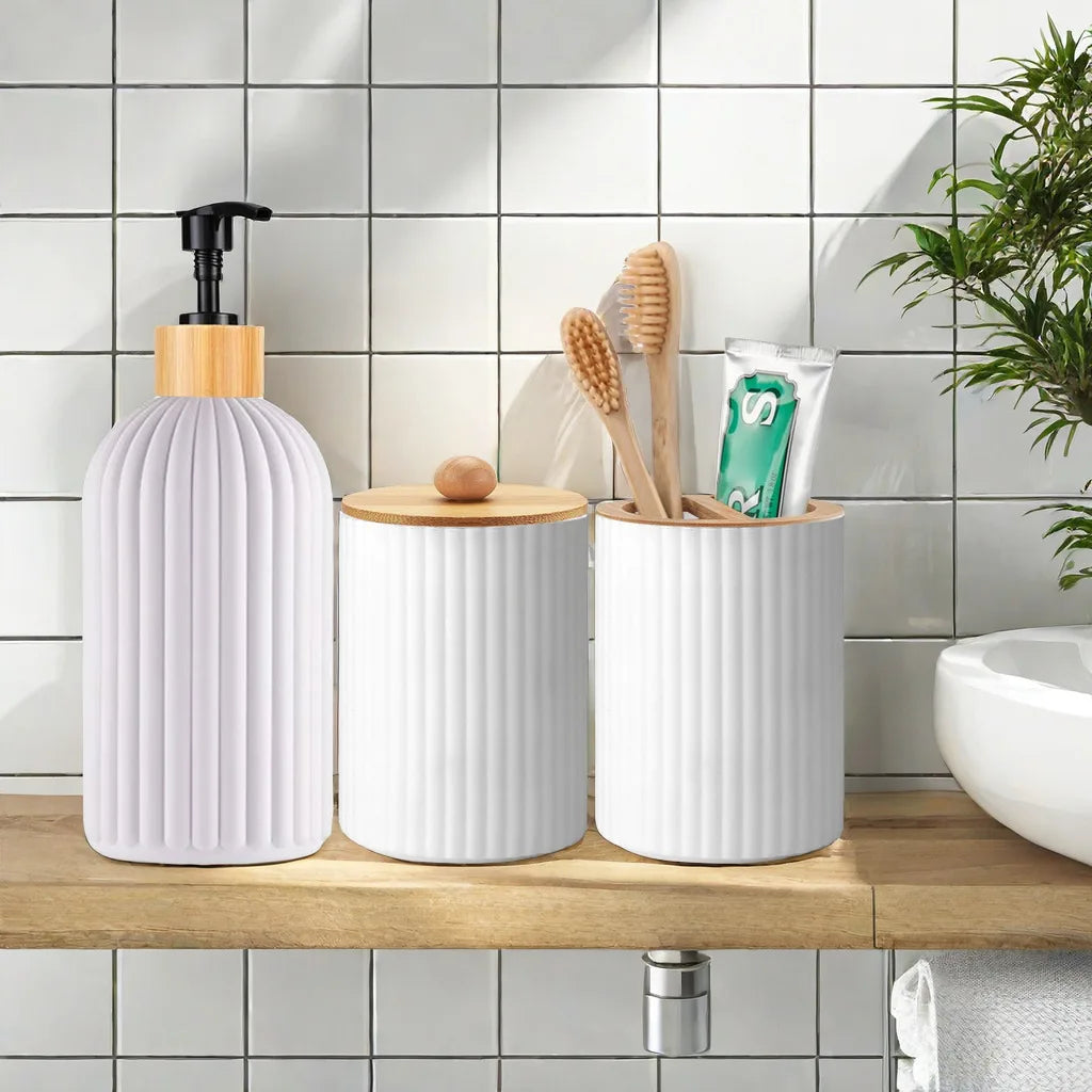 A white bathroom organizer set featuring a soap dispenser, cotton storage, and toothbrush holder on a wooden shelf.