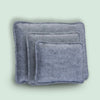 A stack of gray needle felting mats for wool crafting.